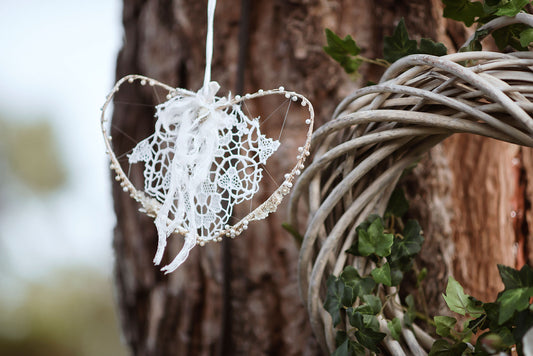 Corazón vintage colgado en un árbol, tejido tejidos a mano en encaje y los bordes con cuentas brillantes, una combinación ideal creada por By Ana Laborda para la boda de Lucía y Juan